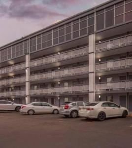 three cars parked in a parking lot in front of a building at Downtown Inn & Studio Suites in Memphis