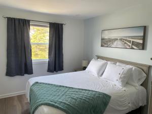 a bedroom with a bed and a window at Buoy & Arrow Suites in Rocky Harbour
