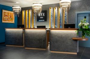 a lobby of a hotel with reception desks and flowers at NYX Hotel Madrid by Leonardo Hotels in Madrid