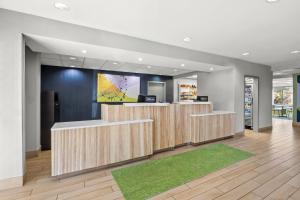 a lobby with a reception desk and a green rug at Spark by Hilton Macon North in Macon +57 photos