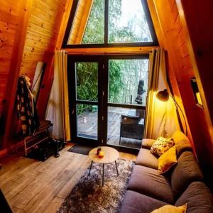 a living room with a couch and a large window at Bambusz-Kabin in Bárdudvarnok
