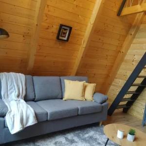 a blue couch in a room with a wooden ceiling at Bambusz-Kabin in Bárdudvarnok +6 photos