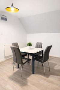 a table with four chairs and a potted plant on it at Modern Spacious Flat In Ipswich - Sleeps 6 - Parking in Freston