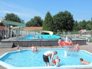 a group of people in a pool at a water park at Geniet van rust en privacy in onze gezellige chalet op familiecamping De Tien Heugten in Drenthe in Schoonloo