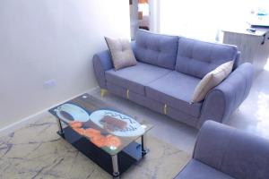 a living room with a blue couch and a coffee table at Aurora Loisse Suites in Nakuru