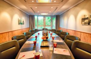 a conference room with a long table and chairs at Leonardo Hotel Köln Bonn Airport in Cologne