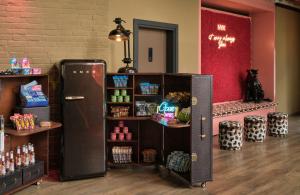 a room with a refrigerator and a shelf of food at NYX Hotel Berlin Köpenick by Leonardo Hotels in Berlin