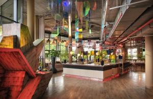 a restaurant with a bar in a large room at NYX Hotel Berlin Köpenick by Leonardo Hotels in Berlin