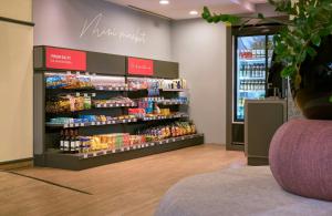 a grocery store aisle with a display of food at Leonardo Hotel Munich Arabellapark in Munich