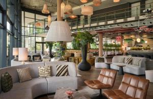 a lobby with couches and chairs in a store at NYX Hotel Berlin Köpenick by Leonardo Hotels in Berlin +38 photos