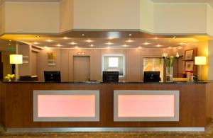a lobby with pink and white signs on a counter at Leonardo Hotel Mönchengladbach in Mönchengladbach +40 photos