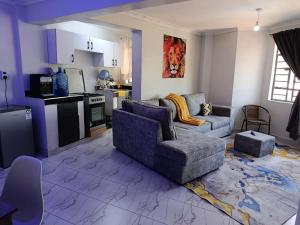 a living room with a couch and a kitchen at T-Homes in Thika