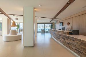 a man standing at a counter in a lobby at Leonardo Royal Hotel Mallorca in Palmanova