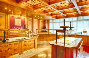 a large kitchen with wooden walls and wooden cabinets at Leonardo Hotel Heidelberg Walldorf in Walldorf +47 photos