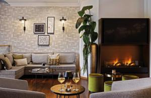 a living room with a couch and a fire place at Leonardo Royal Hotel Frankfurt in Frankfurt +54 photos