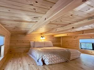 a bedroom with a bed in a log cabin at Cozy Coastal Cabin 2 in Steuben