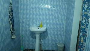 a bathroom with a white sink and a blue wall at Happy Corner Beach Garden in How Ba