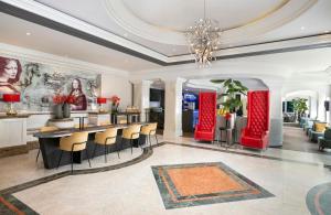 a lobby with a bar with chairs and a chandelier at Leonardo Hotel Düsseldorf City Center in Düsseldorf