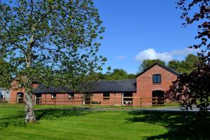 a red brick barn with a black roof at 2 Bed in Llandinam oc-waa377 in Llandinam