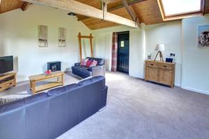 a living room with a blue couch and a tv at 1 Bed in Llandinam oc-waa376 in Llandinam +8 photos