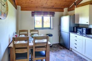 a kitchen with a table and chairs and a refrigerator at 1 Bed in Llandinam oc-waa376 in Llandinam