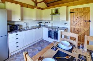 a kitchen with white cabinets and a wooden table at 1 Bed in Llandinam oc-waa376 in Llandinam