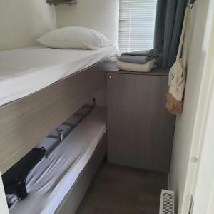 a small room with a bed and a closet at Zeeotter AanZee in Biggekerke