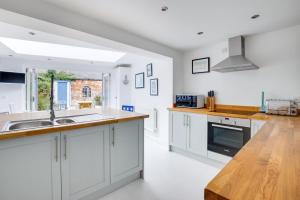 a kitchen with white cabinets and a wooden counter top at 2 Bed in Southwold oc-19cs in Southwold +8 photos