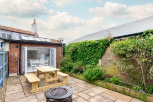 a patio with a wooden table and a bench at 2 Bed in Southwold oc-19cs in Southwold