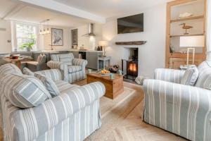 a living room with striped couches and a fireplace at 2 Bed in Fowey oc-m29077 in Fowey