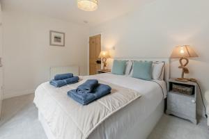 a bedroom with a large white bed with blue towels on it at 2 Bed in Fowey oc-m29077 in Fowey