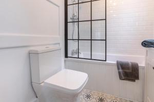a white bathroom with a toilet and a window at 2 Bed in Fowey oc-m29077 in Fowey +24 photos