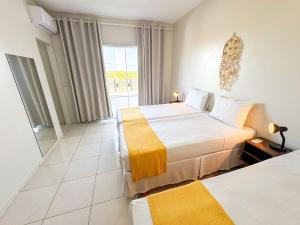una habitación de hotel con dos camas y una ventana en Eficiência - Casa Dascli - Sua Casa em Camocim, en Camocim