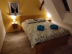 a bedroom with a bed with two blue bags on it at Chez Netty Gite avec sauna à Beblenheim in Beblenheim