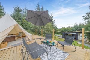 a patio with chairs and an umbrella on a deck at 1 Bed in Austwick oc-r32793 in Eldroth +5 photos