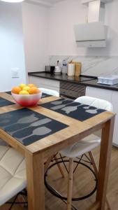 a kitchen with a wooden table with a bowl of fruit on it at Alojamiento Torrevieja playa frente al mar in Torrevieja +26 photos