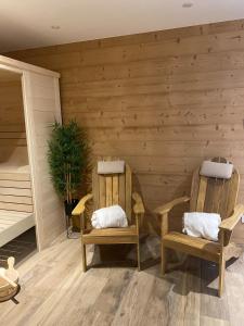 two chairs in a room with wooden walls at Chez Netty Gite avec sauna à Beblenheim in Beblenheim +55 photos