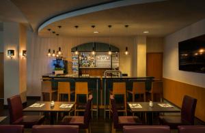 a restaurant with tables and chairs and a bar at Hotel Freiburg City Center by Leonardo Hotels in Freiburg im Breisgau +19 photos