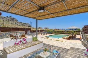 a patio with a couch and a swimming pool at Villa Chloe Seastone by Villa Plus in Kiotari