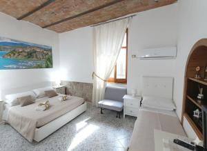 a white bedroom with a bed and a chair at Le Antiche Volte suite in Agropoli