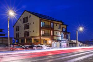 a building on the side of a street at night at Hotel VULTURUL Pitesti in Piteşti