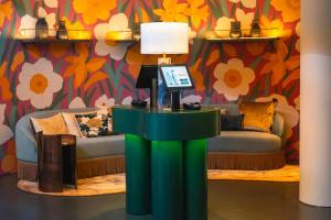 a table with a lamp in a room with a couch at Leonardo Boutique Hotel Maastricht City Center in Maastricht