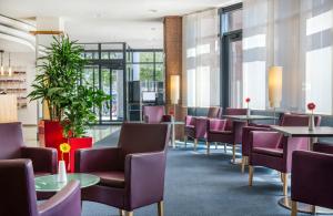 a waiting room with tables and chairs at Hotel Freiburg City Center by Leonardo Hotels in Freiburg im Breisgau