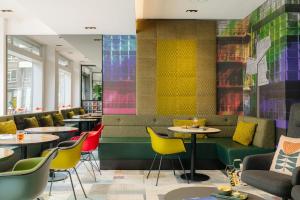 a restaurant with tables and chairs and colorful tiles at Leonardo Hotel Rotterdam Savoy in Rotterdam