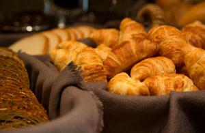 a bunch of croissants and bread on a table at Leonardo Hotel Antwerp The Plaza in Antwerp