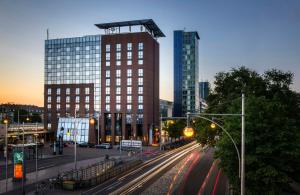 a city with tall buildings and street lights and cars at Hotel Freiburg City Center by Leonardo Hotels in Freiburg im Breisgau
