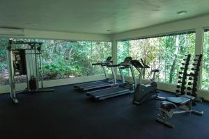 a gym with three tread machines and a large window at Fazenda Shanti in Alto Paraíso de Goiás