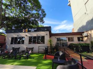 a patio with chairs and grass in front of a building at Terra Iguazú Suites in Puerto Iguazú