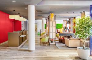 a lobby of a hotel with red walls at Hotel Nürnberg City Center by Leonardo Hotels in Nuremberg