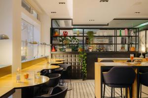 a restaurant with a bar with tables and chairs at Leonardo Hotel Rotterdam Savoy in Rotterdam